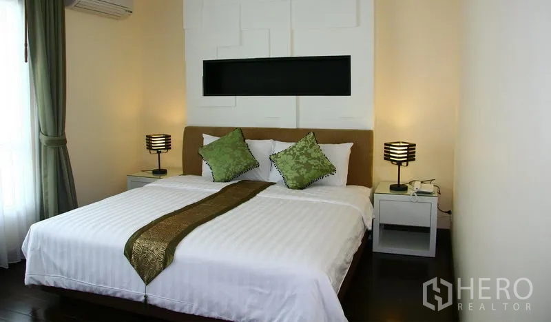 Apartment for rent in Khlong Toei, Bangkok - Guest bedroom with white feature wall, king bed and green cushions