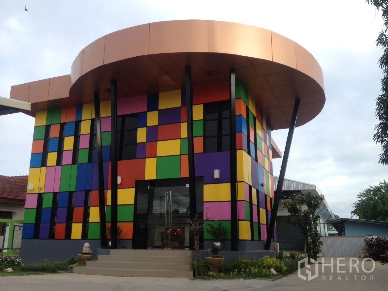 คลังสินค้า for sale in Bang Bon, Bangkok - ด้านหน้าออฟฟิศสีสันสด หลังคาโค้ง และเสาเอียงโดดเด่น