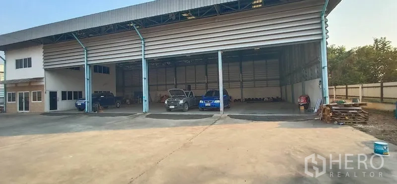 货栈 出租在Khlong Luang, Pathum Thani - 三个宽幅卷帘门，前方为停车与装卸区。