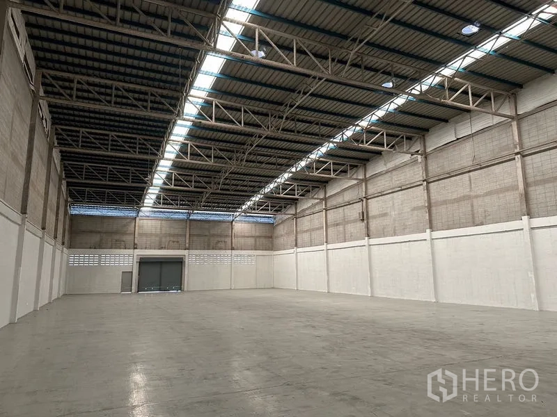 Factory for rent in Si Racha, Chon Buri - Open warehouse hall with steel truss roof and skylight strips for natural light.