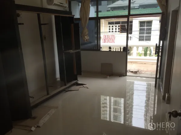 ทาวน์เฮาส์ ให้เช่าในKhlong Toei, Bangkok - ห้องชั้นบนสว่าง พื้นเงา กระจกบานใหญ่ และประตูออกระเบียงมองเห็นบ้านข้างเคียง