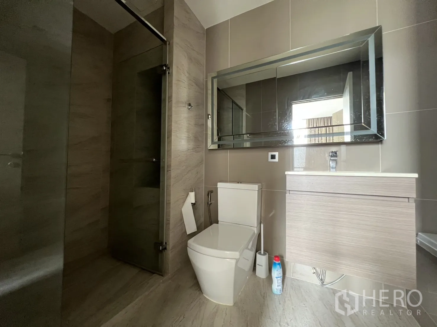 公寓 for rent in Watthana, Bangkok - 现代卫浴含玻璃淋浴间、悬挂式洗手台与坐便器。