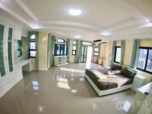 Townhouse for rent in Watthana, Bangkok - Extra-large master bedroom with built-in storage, desk, multiple windows and glossy floors.