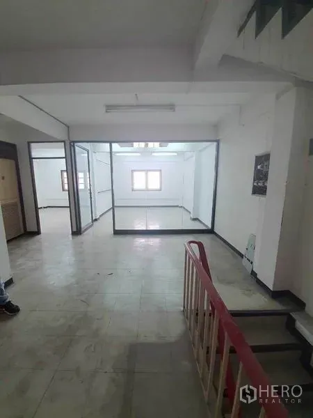 店屋 出租在Bang Rak, Bangkok - 铺内开放式楼层，瓷砖地面，楼梯与玻璃隔间办公室。