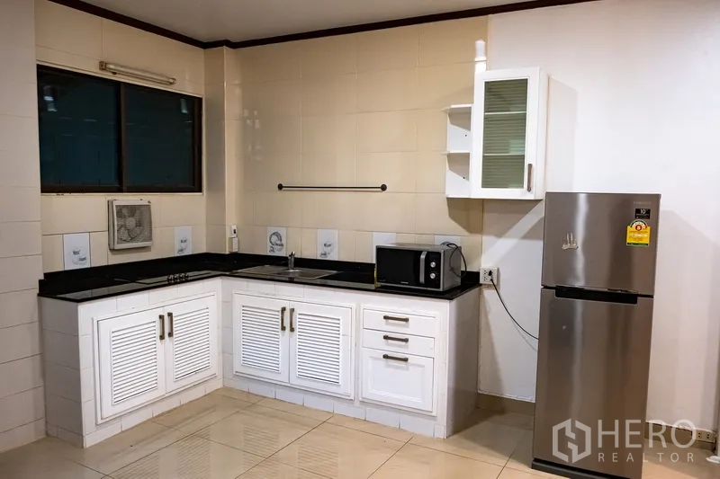 สำนักงานที่บ้าน ให้เช่าในKhlong Toei, Bangkok - ครัวรูปตัวแอลหน้าบานสีขาว ท็อปหินดำ ตู้เย็นและไมโครเวฟครบ