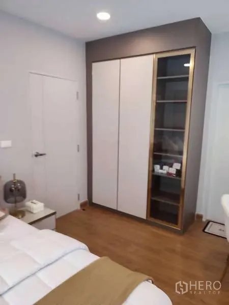 Detached House for rent in Bang Phli, Samut Prakan - Bedroom corner featuring a built-in wardrobe and wood flooring beside a white door.