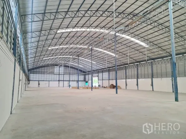 Warehouse for sale in Phra Samut Chedi, Samut Prakan - Clear-span warehouse interior with high arched steel roof, skylights and open loading floor.