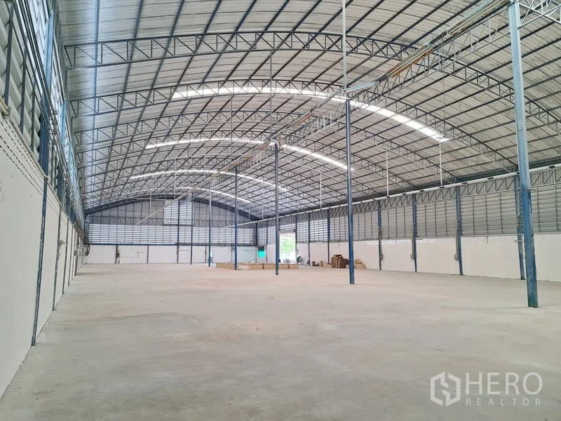 Warehouse for sale in Phra Samut Chedi, Samut Prakan - Clear-span warehouse interior with high arched steel roof, skylights and open loading floor.
