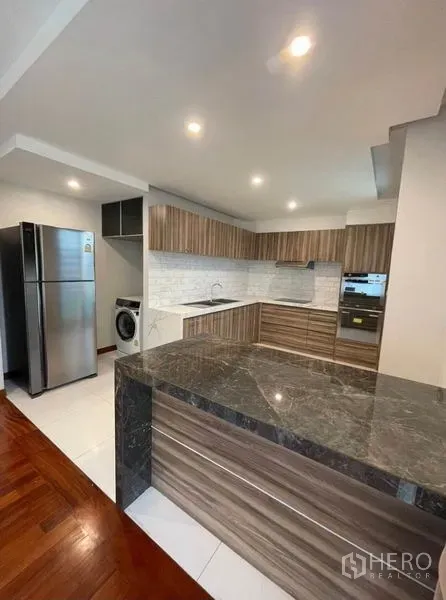 คอนโด ให้เช่าในKhlong Toei, Bangkok - ครัวรูปตัวยู ท็อปหินสโตน ตู้ลายไม้ ผนังกระเบื้องซับเวย์ ตู้เย็นและเครื่องซักผ้า