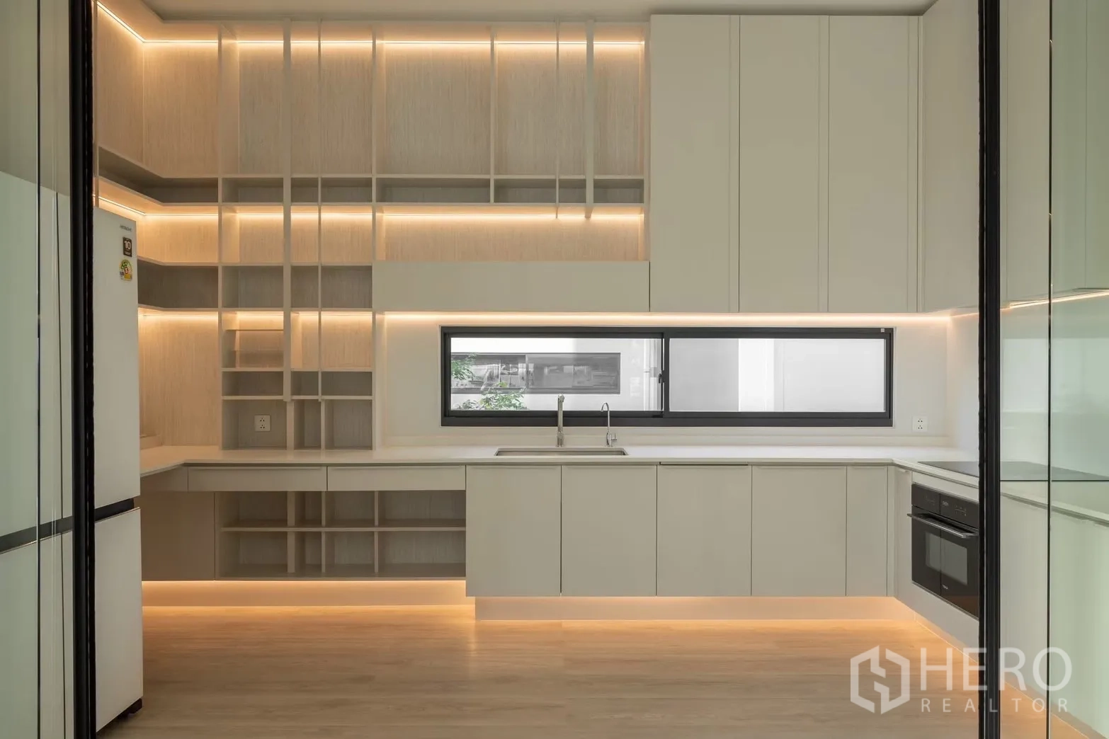 Detached House for rent in Saphan Sung, Bangkok - Minimalist kitchen with light cabinetry, long window, and under-cabinet LED lighting.