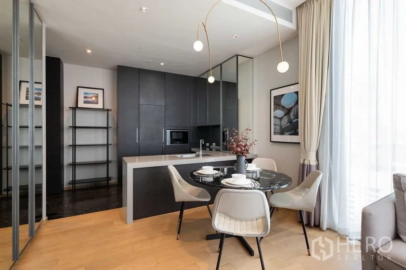 Condominium for rent - Open kitchen with dark cabinetry, breakfast island and dining set under pendant lights.
