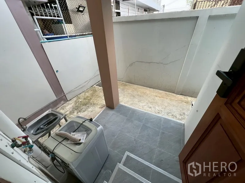 บ้าน ขายในPhra Khanong, Bangkok - มุมซักล้างขนาดเล็กพร้อมอ่างล้างมือ เครื่องซักผ้า และพื้นกระเบื้อง