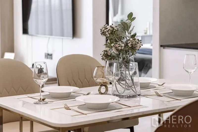 公寓 出租在Bang Rak, Bangkok - 四人餐桌布置完成，配酒杯、餐具与花艺装饰。