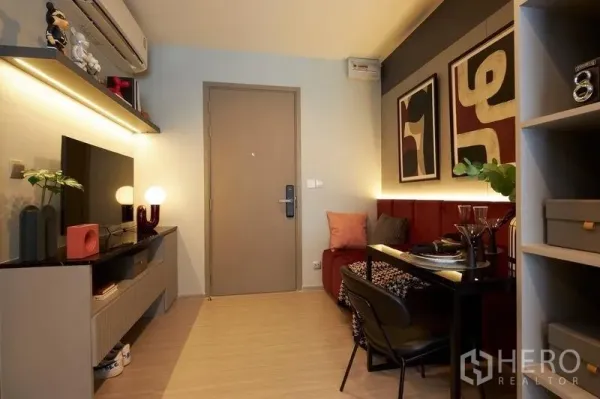 公寓 出售在Ratchathewi, Bangkok - 现代公寓客厅，电视柜、暖色灯光与小型用餐区。