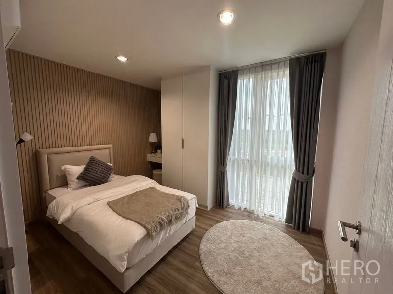 货栈 出售在Pathum Thani - 温馨卧室，落地窗、窗帘与内置衣柜，位于办公居住区。