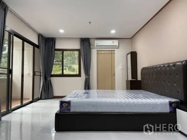 公寓 出租或出售在Watthana, Bangkok - 宽敞主卧，大片窗户、阳台出入口与空调。