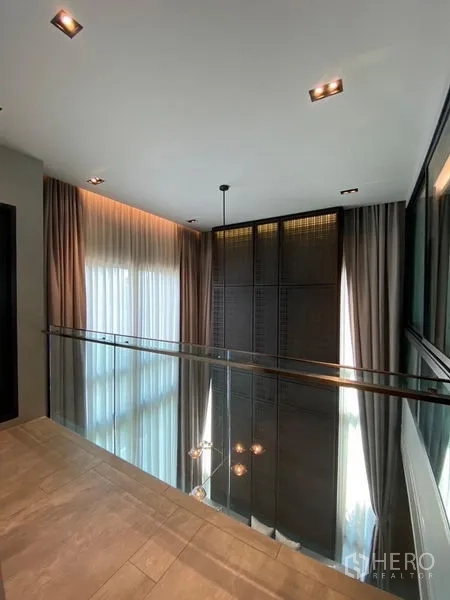 บ้าน ขายในPhaya Thai, Bangkok - โถงชั้นลอยราวกระจก มองลงสู่ห้องนั่งเล่นเพดานสูงด้านล่าง