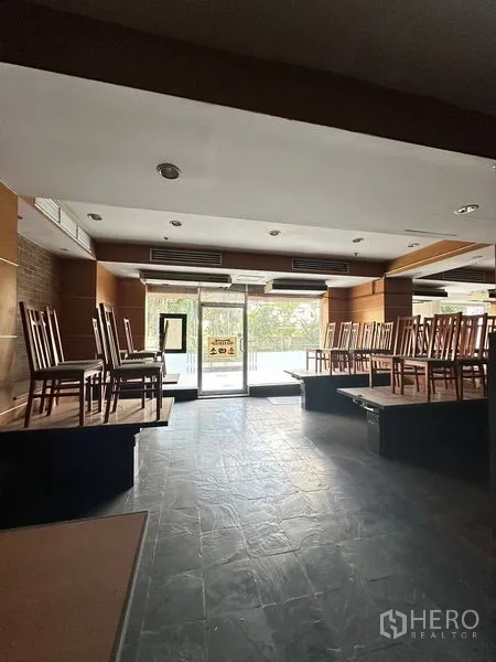 零售空间 出租在Yan Nawa, Bangkok - 开放式零售区域，带大面积落地窗和抬高座位平台。