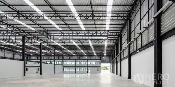 คลังสินค้า ให้เช่า - พื้นที่คลังสินค้ากว้างโปร่ง เพดานสูงประมาณ 10 ม. โครงทรัสเหล็กและช่องรับแสง พร้อมบล็อกออฟฟิศ