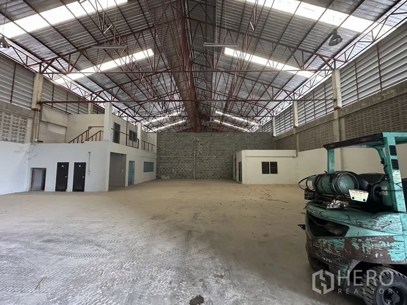 货栈 出租在Khlong Sam Wa, Bangkok - 开阔仓储区，钢桁架屋顶与采光板，内置办公室，角落停放叉车