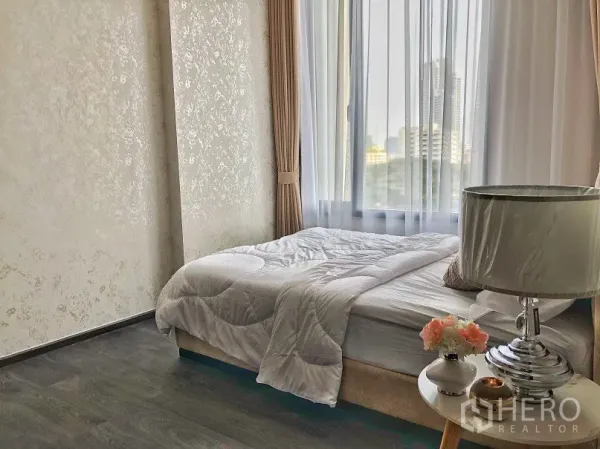 คอนโด ให้เช่าในWatthana, Bangkok - ห้องนอนสว่างด้วยหน้าต่างบานใหญ่ ผ้าม่านโปร่ง โต๊ะข้างเตียง และวิวสกายไลน์ของเมือง