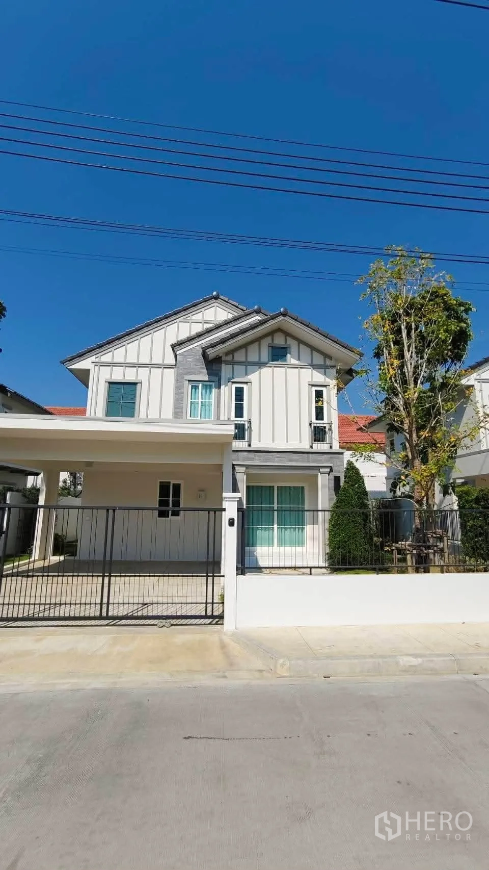 独立式住宅 for rent in Bang Phli, Samut Prakan - 两层独栋别墅外立面，带入户围栏、车棚与前庭景观。