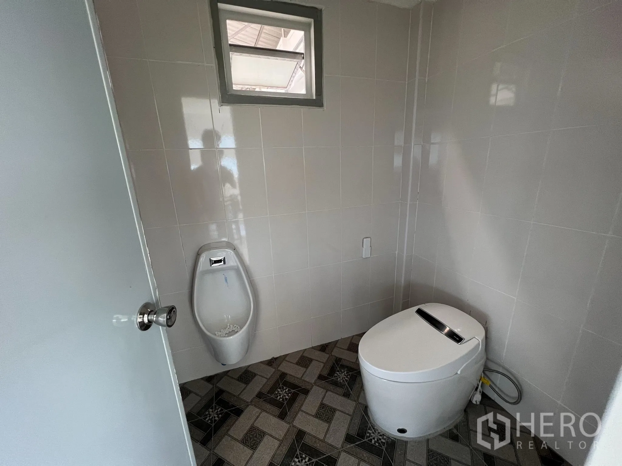 Warehouse for sale in Lat Lum Kaeo, Pathum Thani - Tiled restroom featuring a smart toilet, urinal and ventilation window.