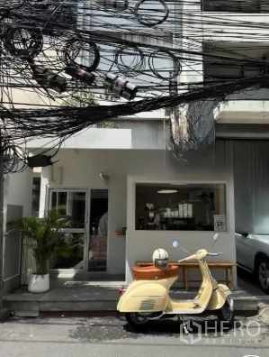 零售空间 出租在Watthana, Bangkok - 通罗区域临街商铺外观，玻璃门与服务窗，瓦塔那区曼谷。