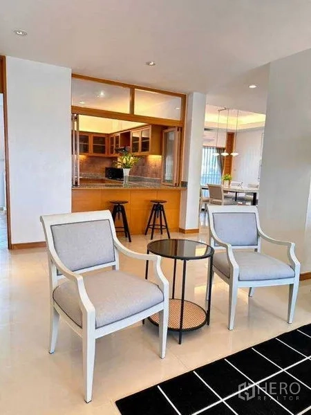 Apartment for rent - Pair of accent chairs and round side table beside the kitchen bar.