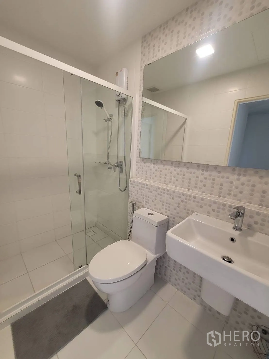 联排别墅 出租在Prawet, Bangkok - 明亮浴室，超大镜面、玻璃淋浴与白色洁具。