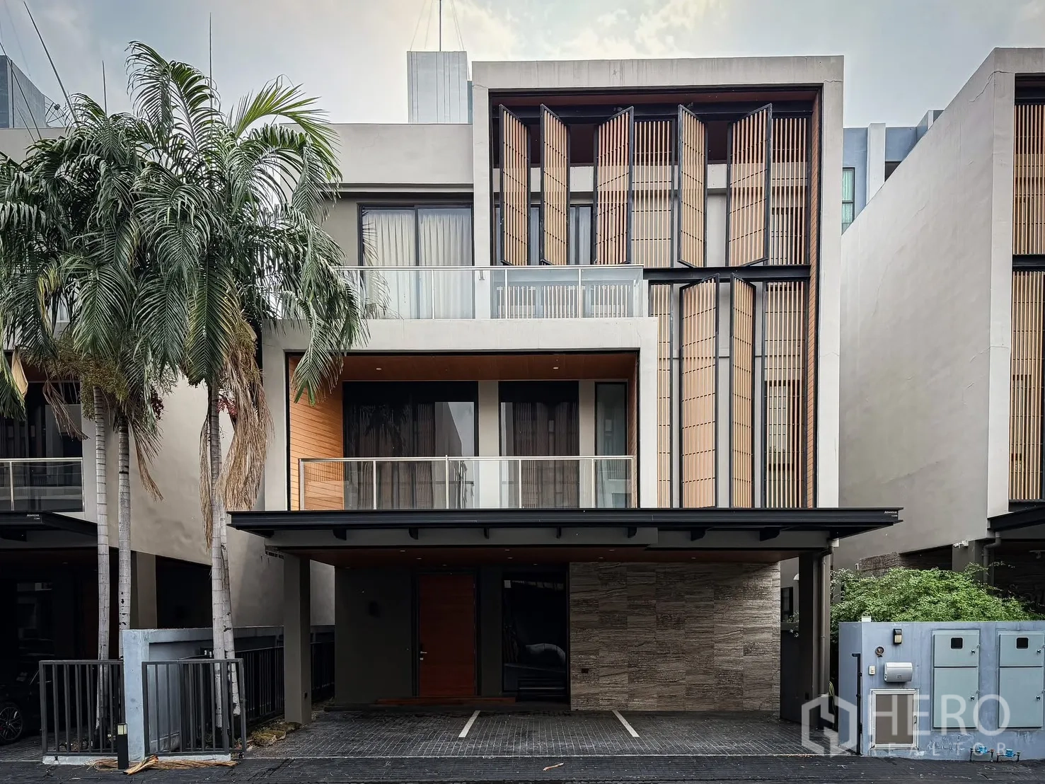 Detached House for rent or sale in Lak Si, Bangkok - Modern detached house exterior with balconies, vertical screens, and a covered carport.