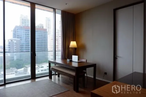 Condominium for sale in Khlong Toei, Bangkok - Dining or work nook beside full-height glass doors overlooking the Bangkok skyline.