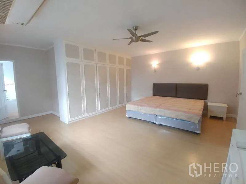 公寓 出租或出售在Watthana, Bangkok - 主卧角度，特大床、吊扇及大量内置衣柜。