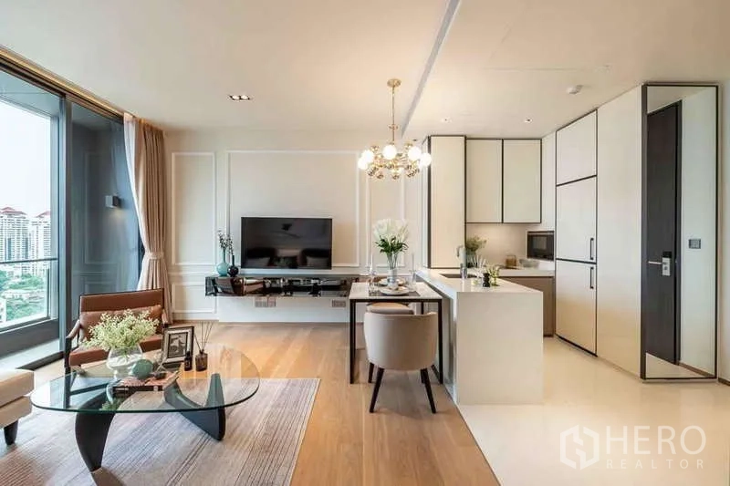 คอนโด ให้เช่าหรือขายในKhlong Toei, Bangkok - ห้องนั่งเล่นโอเพนแปลนพร้อมทีวี ชุดรับประทานอาหาร และครัวสไตล์โมเดิร์นโทนขาว