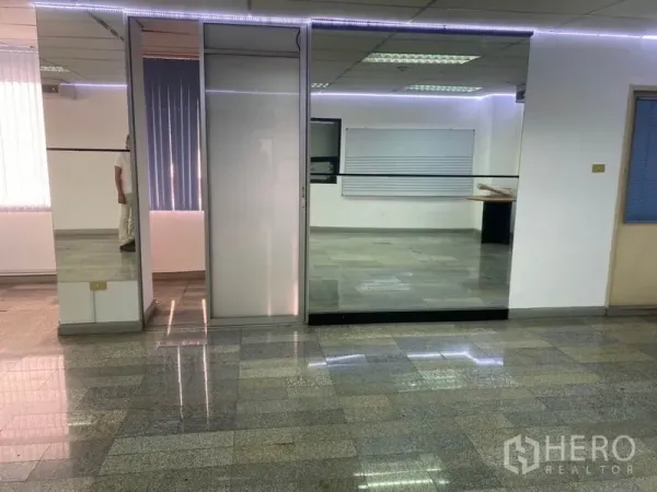 Office Space for rent in Khlong Toei, Bangkok - Office entrance area featuring a floor-to-ceiling glass partition, mirror paneling and subtle LED strip lighting.