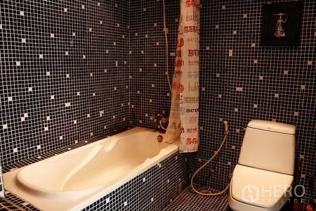 Condominium for rent in Ratchathewi, Bangkok - Bathroom with mosaic tile walls, bathtub with handheld shower and toilet.