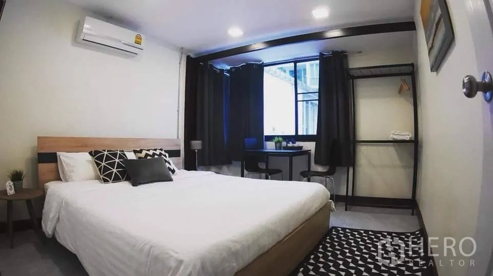 独栋房屋 for rent in Watthana, Bangkok - 明亮卧室配双人床、窗户、书桌、开放衣架与空调。