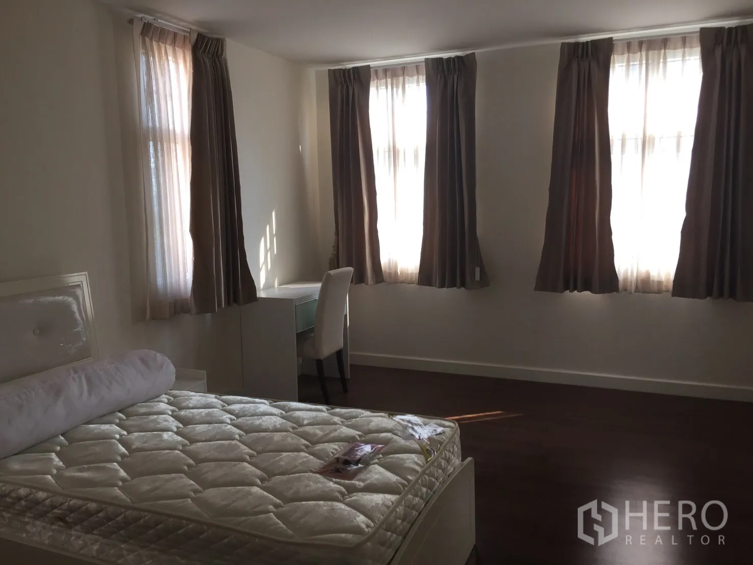 联排别墅 出租在Watthana, Bangkok - 宽敞卧室，多扇窗配窗帘，带床与书桌，木质地板。