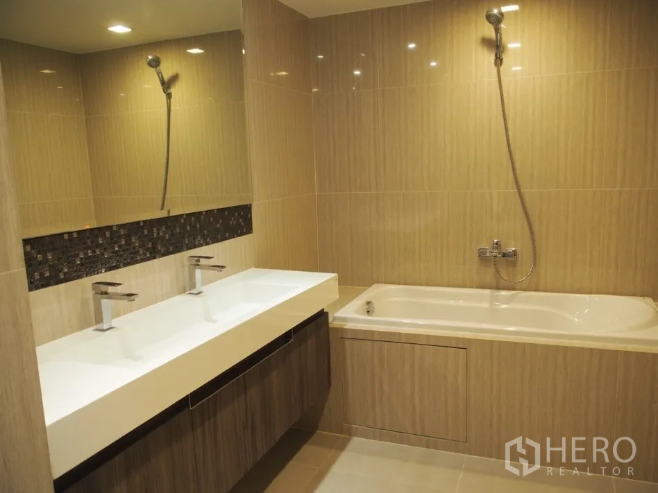 คอนโด for rent or sale in Watthana, Bangkok - ห้องน้ำสไตล์โมเดิร์นพร้อมอ่างล้างหน้าแบบคู่ อ่างอาบน้ำ และฝักบัวติดผนัง
