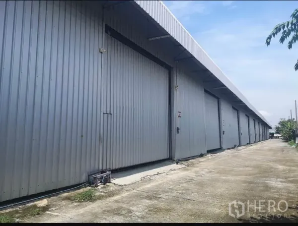 货栈 出租在Lam Luk Ka, Pathum Thani - 多联金属外墙仓库外立面，超宽推拉门与宽阔混凝土通道