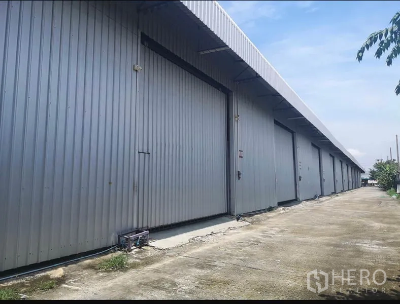 货栈 出租在Lam Luk Ka, Pathum Thani - 多联金属外墙仓库外立面，超宽推拉门与宽阔混凝土通道