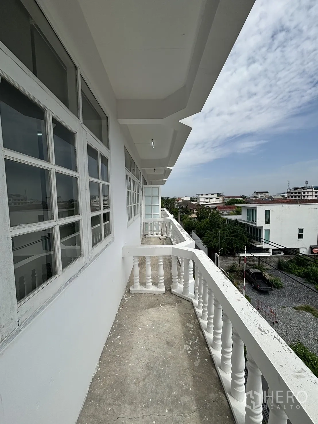 Home Office for rent in Phra Khanong, Bangkok - Long exterior balcony with classic balustrade and urban views.