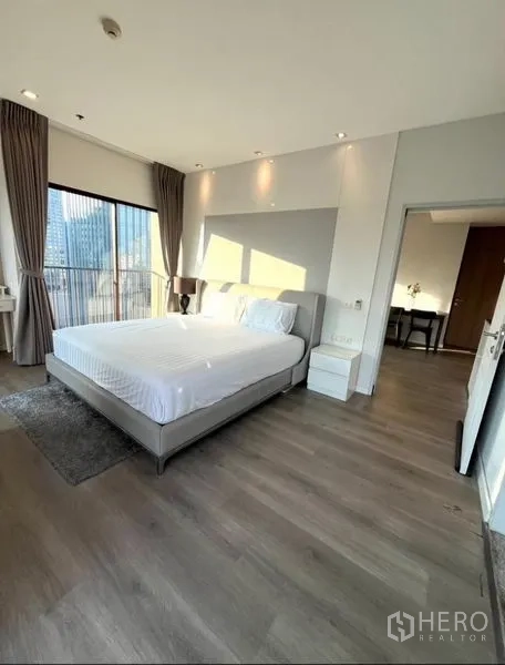 คอนโด ให้เช่าในBangkok - ห้องนอนกว้าง เตียงคิงไซส์ พื้นไม้ และหน้าต่างมุมสูงชมวิวเมือง