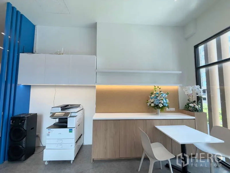 Office Space for rent in Huai Khwang, Bangkok - Business corner with multifunction printer, storage cabinets and a small seating area by the window.