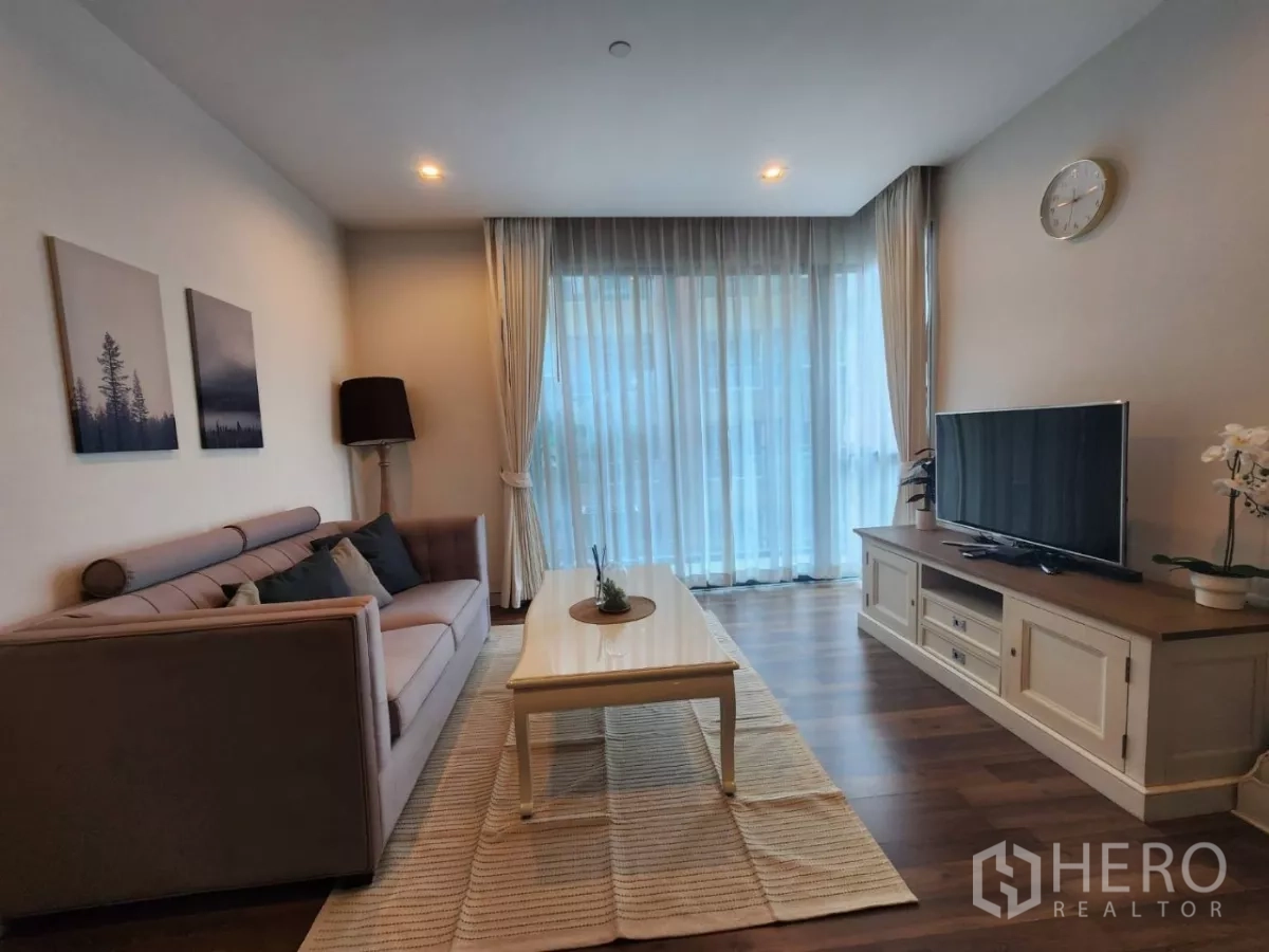 คอนโด ให้เช่าในPhra Khanong, Bangkok - มุมทีวีตรงข้ามโซฟา ในห้องนั่งเล่นโปร่งสว่างพื้นไม้