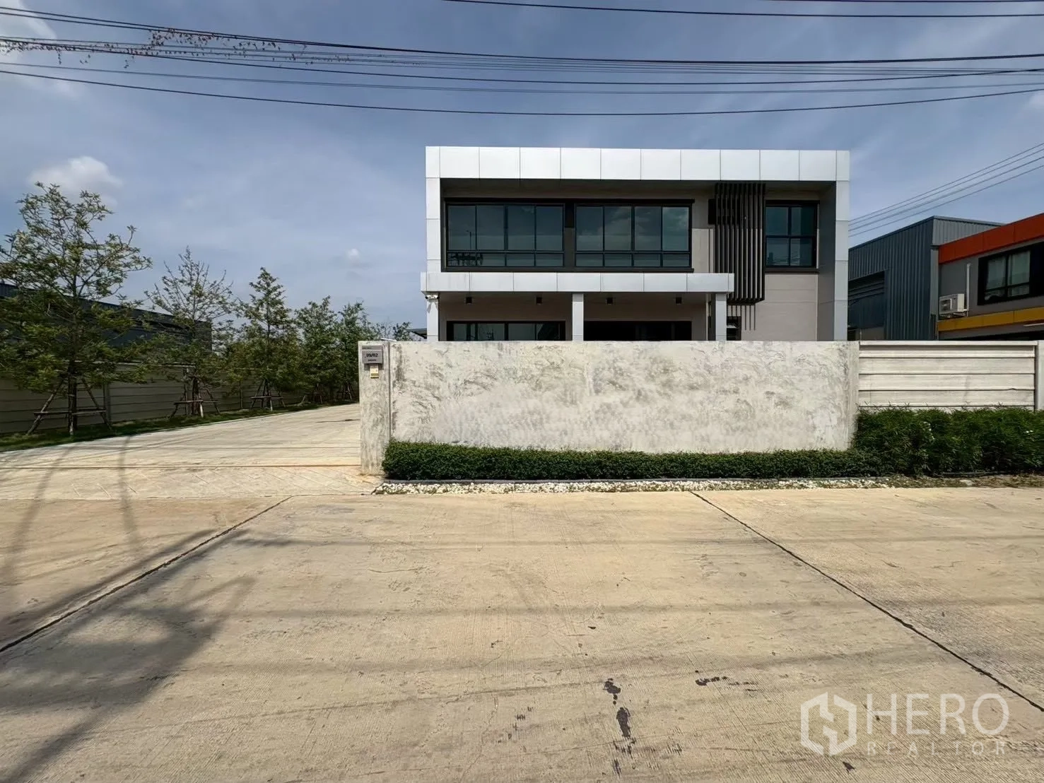 โรงงาน for rent or sale in Bang Len, Nakhon Pathom - มุมมองจากถนนเห็นออฟฟิศสองชั้นสไตล์โมเดิร์นของโรงงานหลังกำแพงรั้วและทางเข้าประตู
