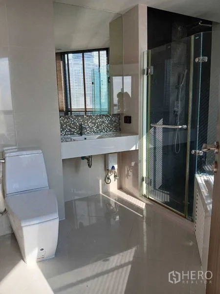 คอนโด ให้เช่า - ห้องน้ำสว่าง ตู้อาบน้ำกระจก อ่างล้างหน้า และโถสุขภัณฑ์