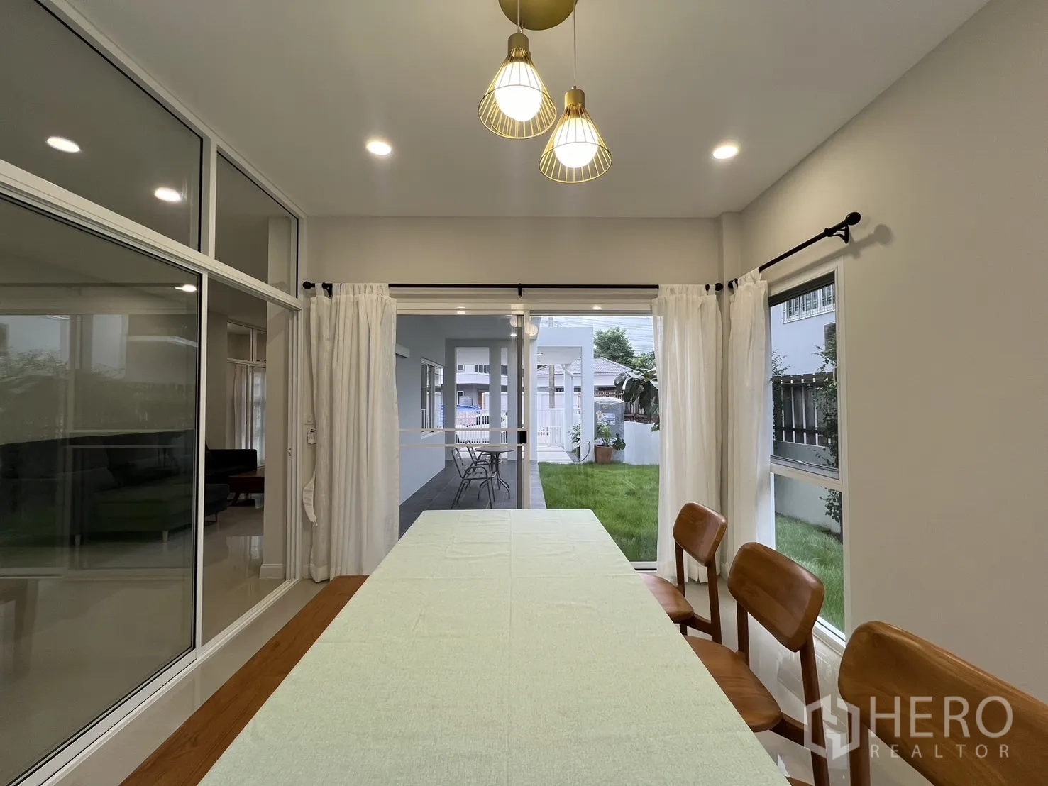 Detached House for rent in Saphan Sung, Bangkok - Dining space facing carport and garden through large glass doors.