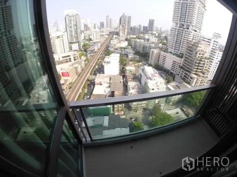 公寓 出租在Khlong Toei, Bangkok - 高楼层阳台俯瞰素坤逸城市天际线与BTS轨道景观。