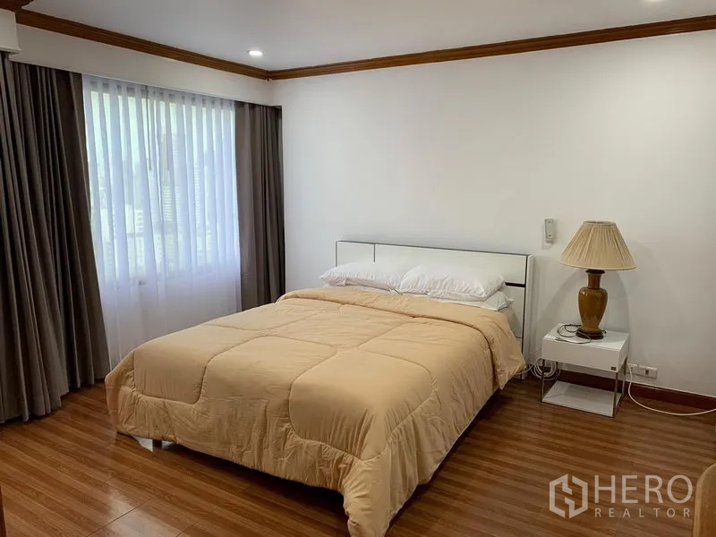 คอนโด ให้เช่าในWatthana, Bangkok - ห้องนอนอบอุ่น พื้นไม้ ผ้าม่าน และโคมไฟข้างเตียง ที่ Liberty Park 1 สุขุมวิท 23